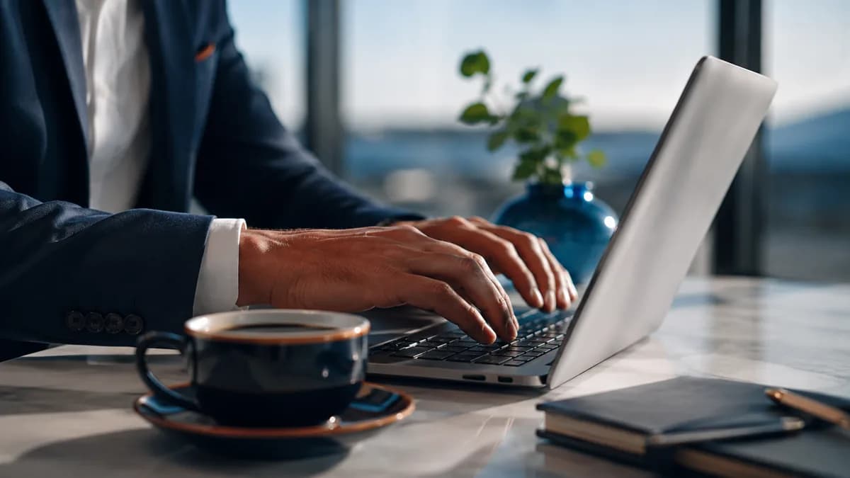 Hände auf einer Computertastatur mit einer Tasse Kaffee, Illustration des Verfassens einer E-Mail-Vorlage für die Erstattung